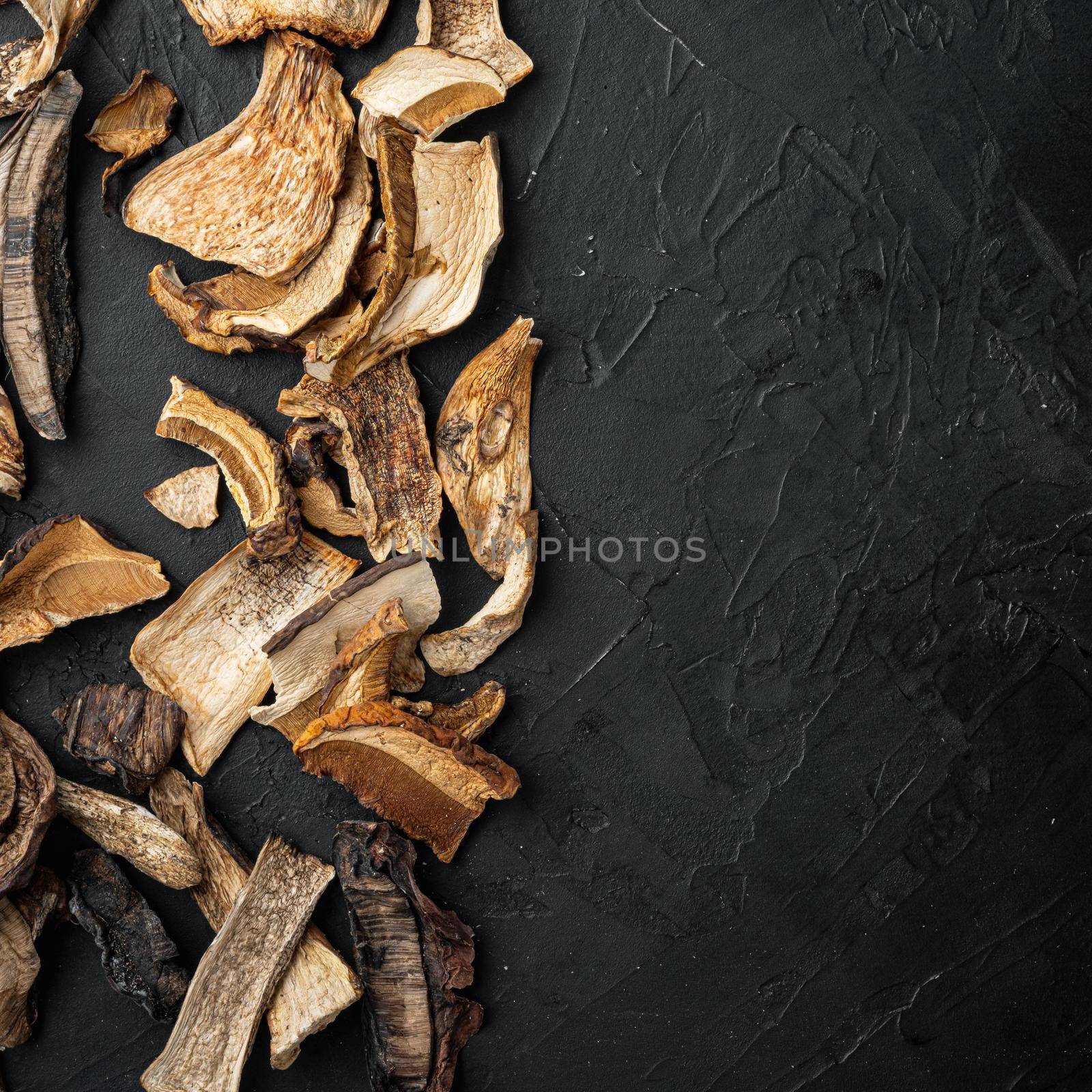 Boletus wild dried mushrooms, on black background, top view flat lay , with space for text copyspace by Ilianesolenyi