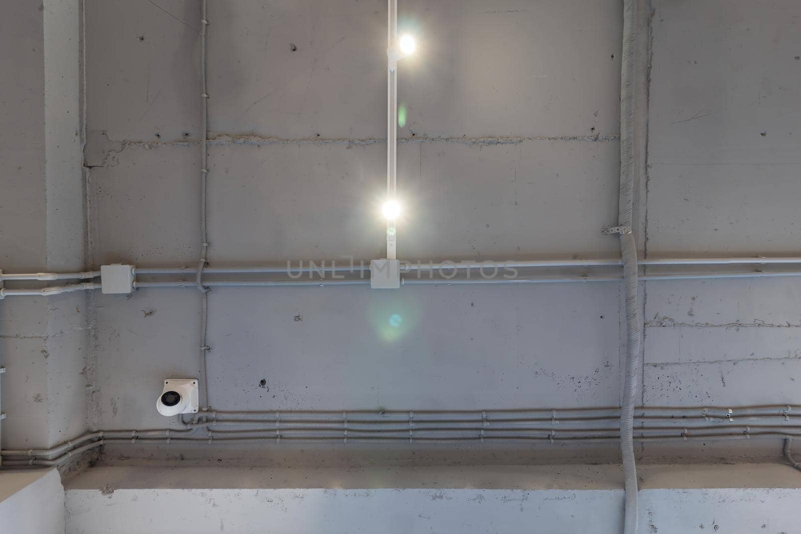 Interior architecture and ceiling design of industrial loft building decorated with modern lamps, glass windows and wall speakers