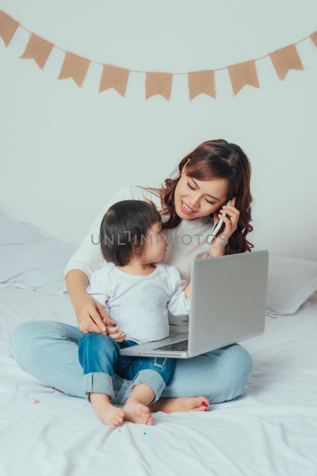 Working mother with her daughter in bedroom at home