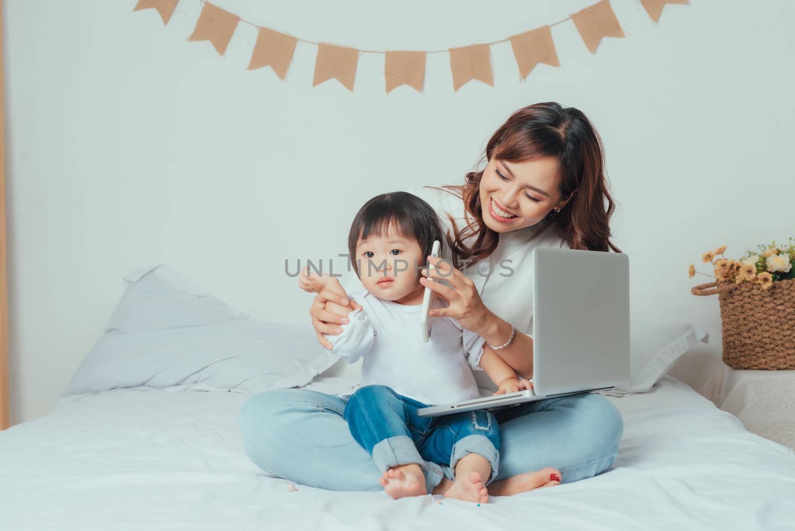 Daughter beside young mother using wireless technology