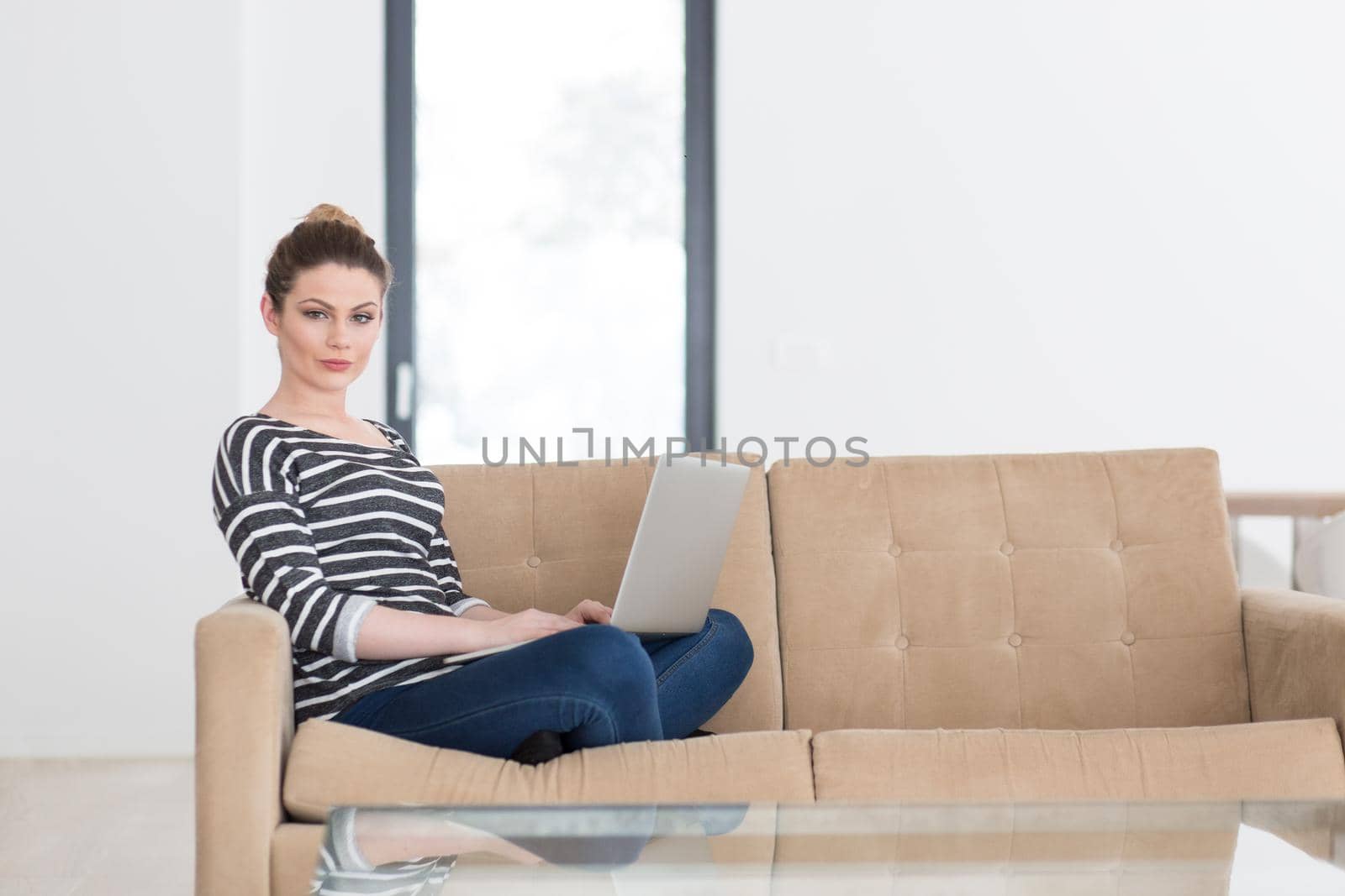 young woman on sofa at home websurfing by dotshock