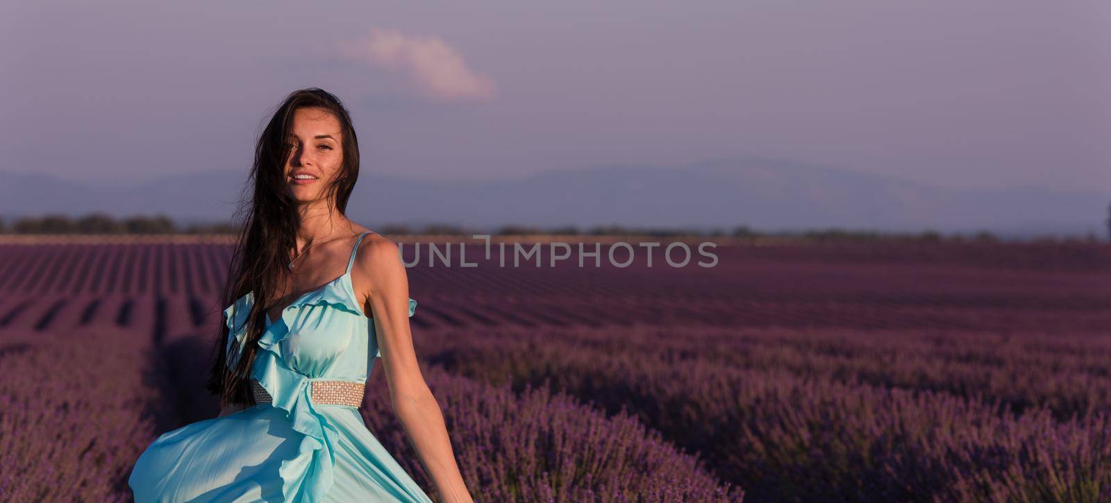 lavander flower field woman in cyand dress having fun and relax on wind in  purple flower field