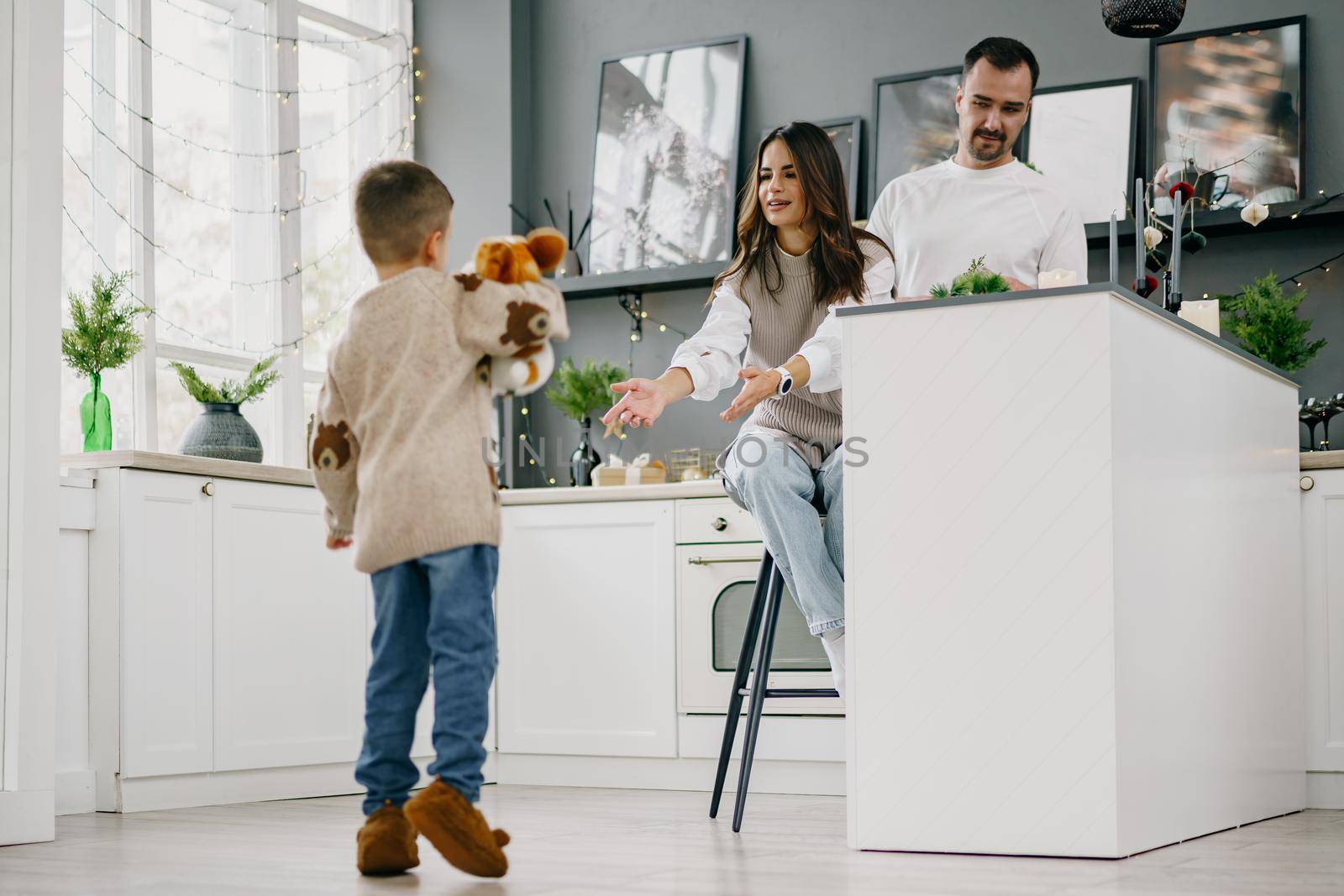 Happy young family spending time together in kitchen at home at Christmas holidays