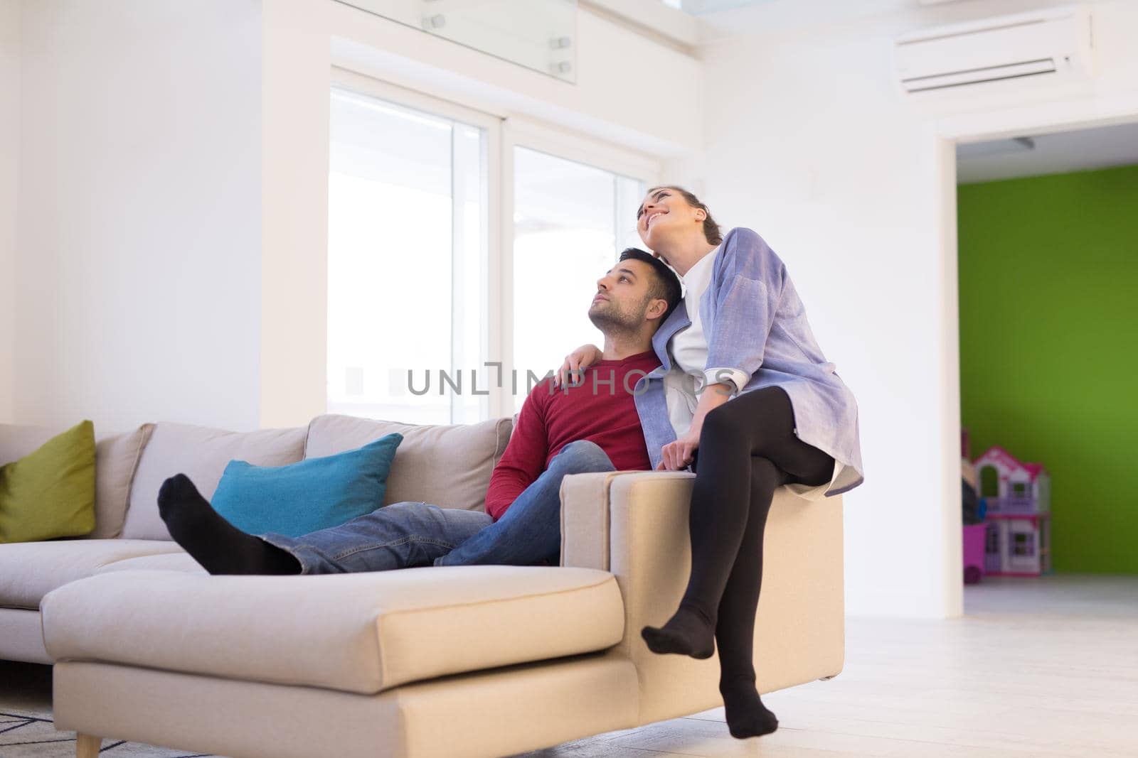 Happy young couple hugging and relaxing on sofa at home