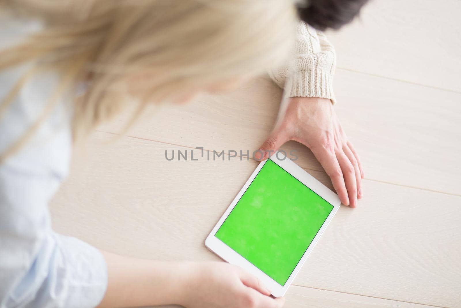 Young Couple on the floor in front of fireplace surfing internet using digital tablet on cold winter day