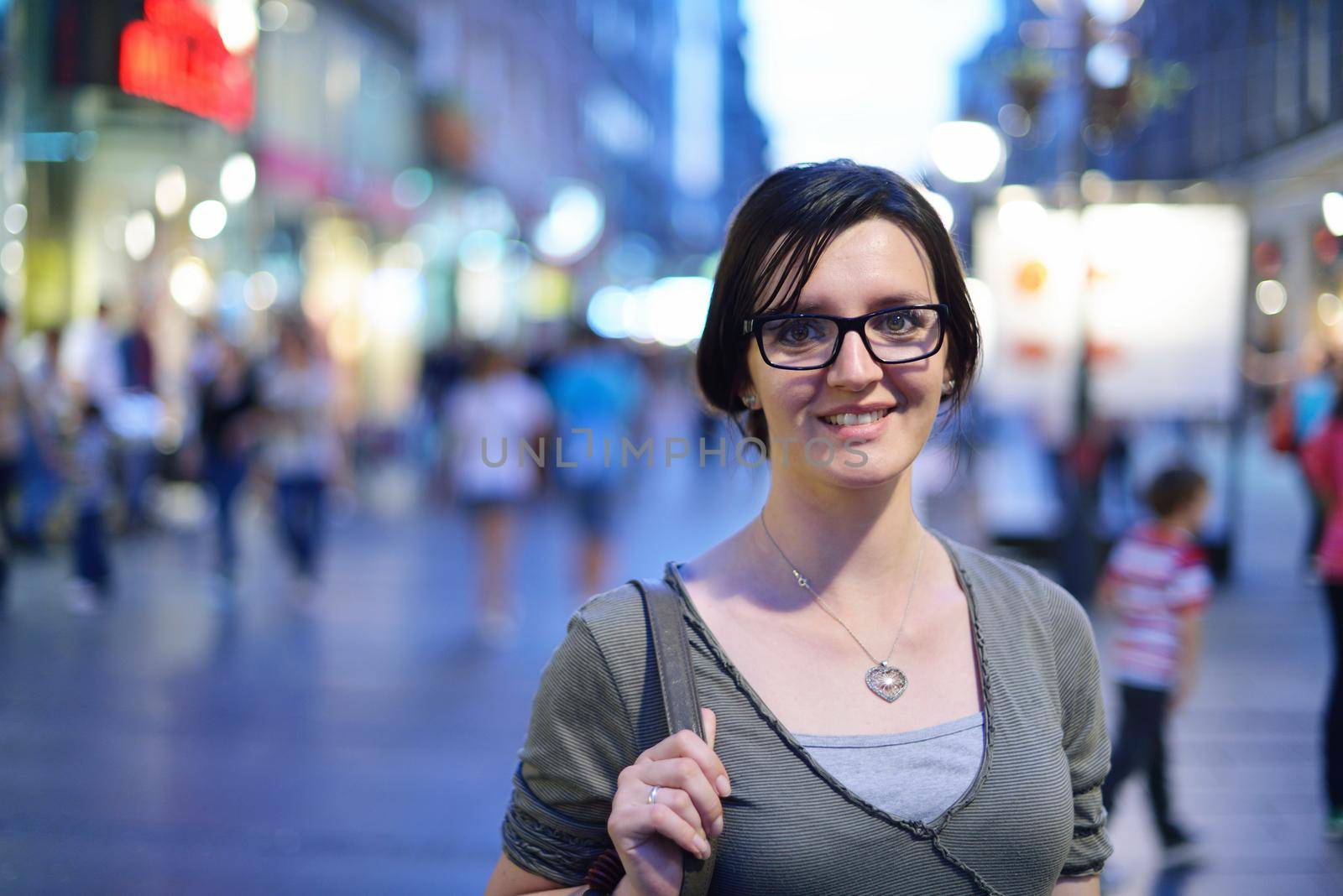 portrait of young woman on street at night in city street