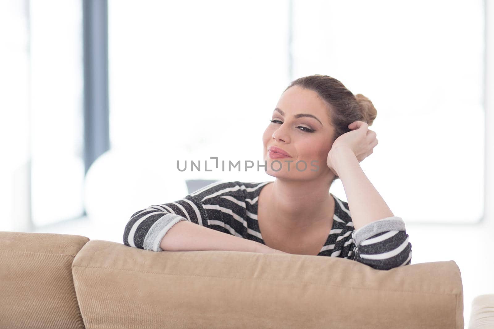 portrait of a young beautiful woman sitting on the sofa by dotshock