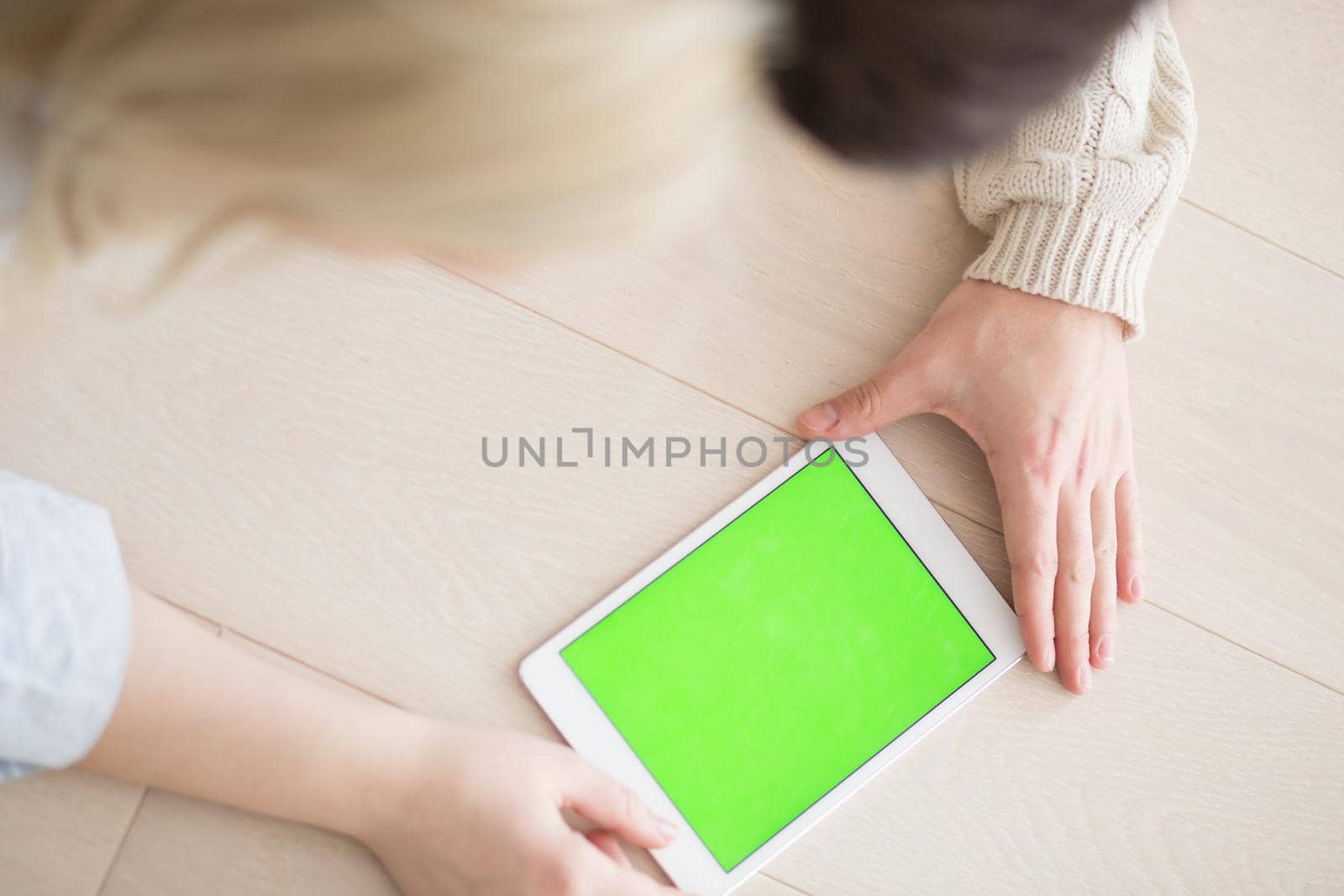 Young Couple on the floor in front of fireplace surfing internet using digital tablet on cold winter day