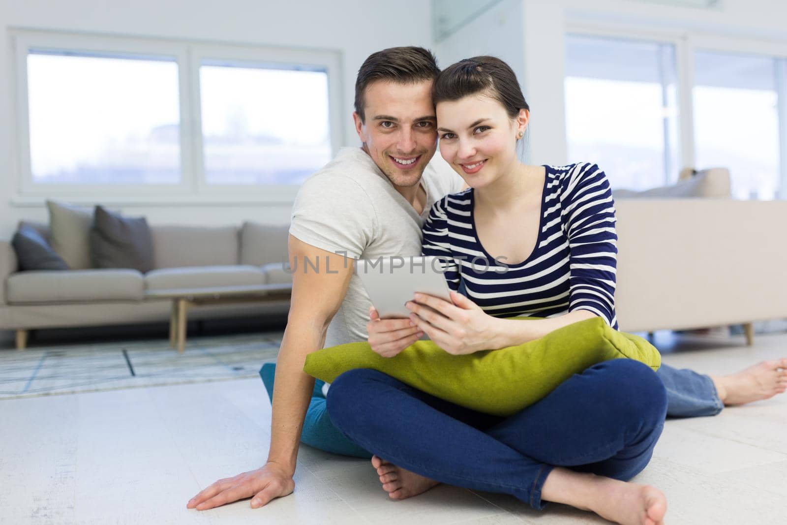 Young Couple using digital tablet on the floor by dotshock