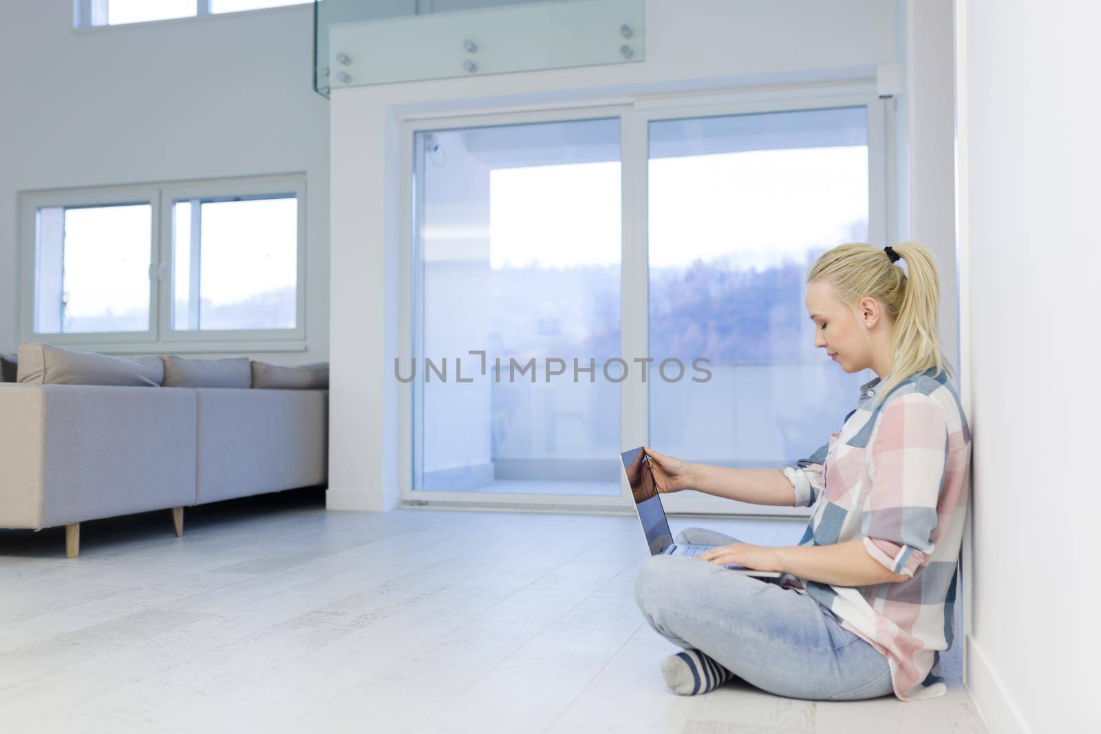 young woman using laptop computer on the floor by dotshock