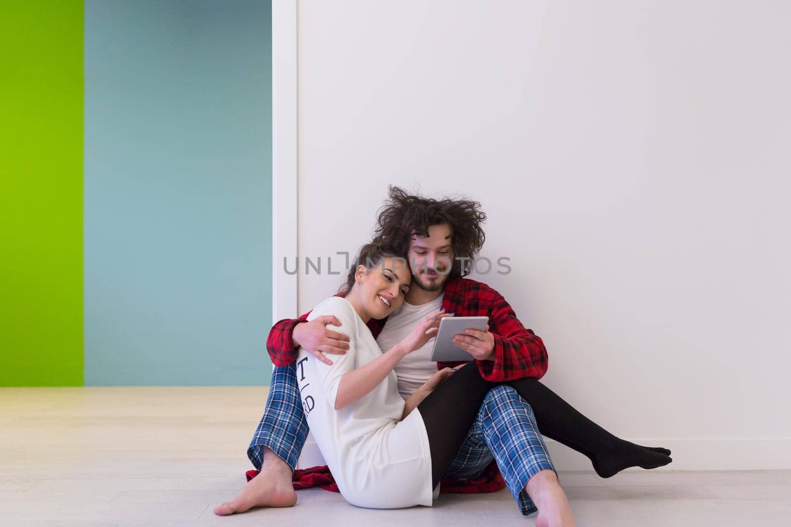 Young Couple sitting on the floor and using interent on digital tablet