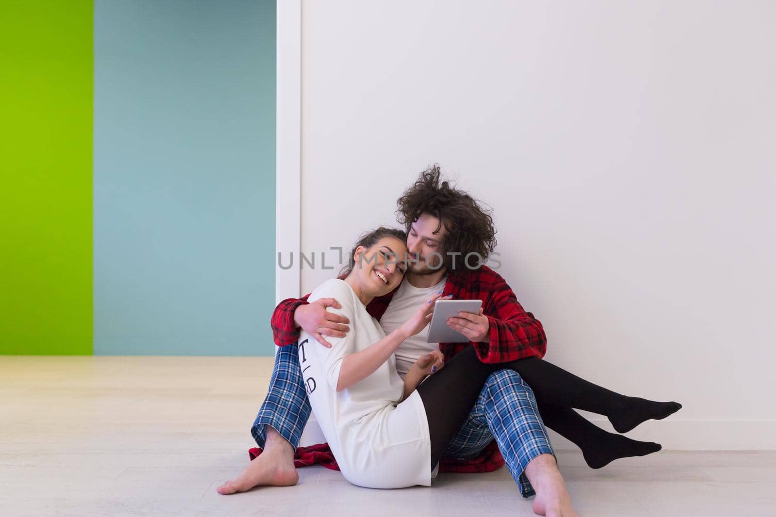 Young Couple using digital tablet on the floor by dotshock