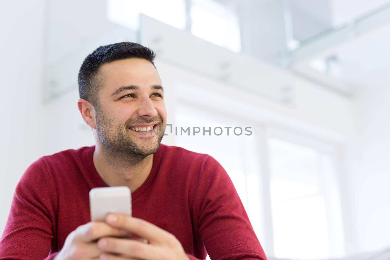 young man using a mobile phone  at home by dotshock