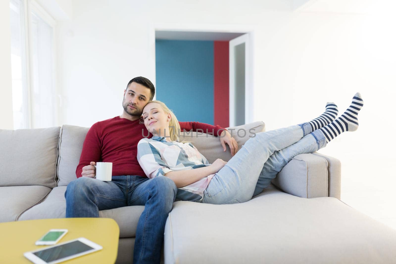 Happy young couple hugging and relaxing on sofa at home