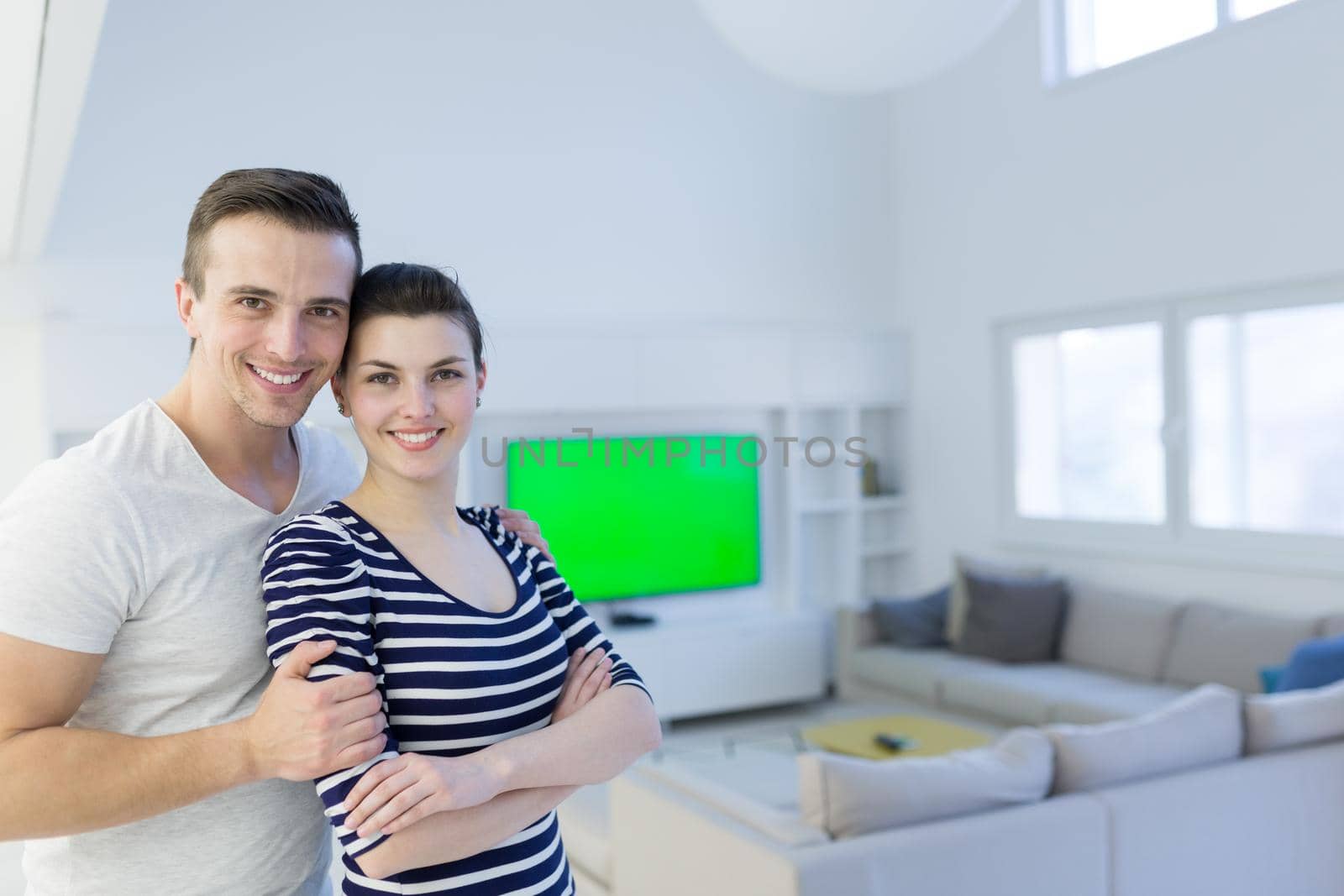 Portrait of a happy young beautiful couple hugging in their new home