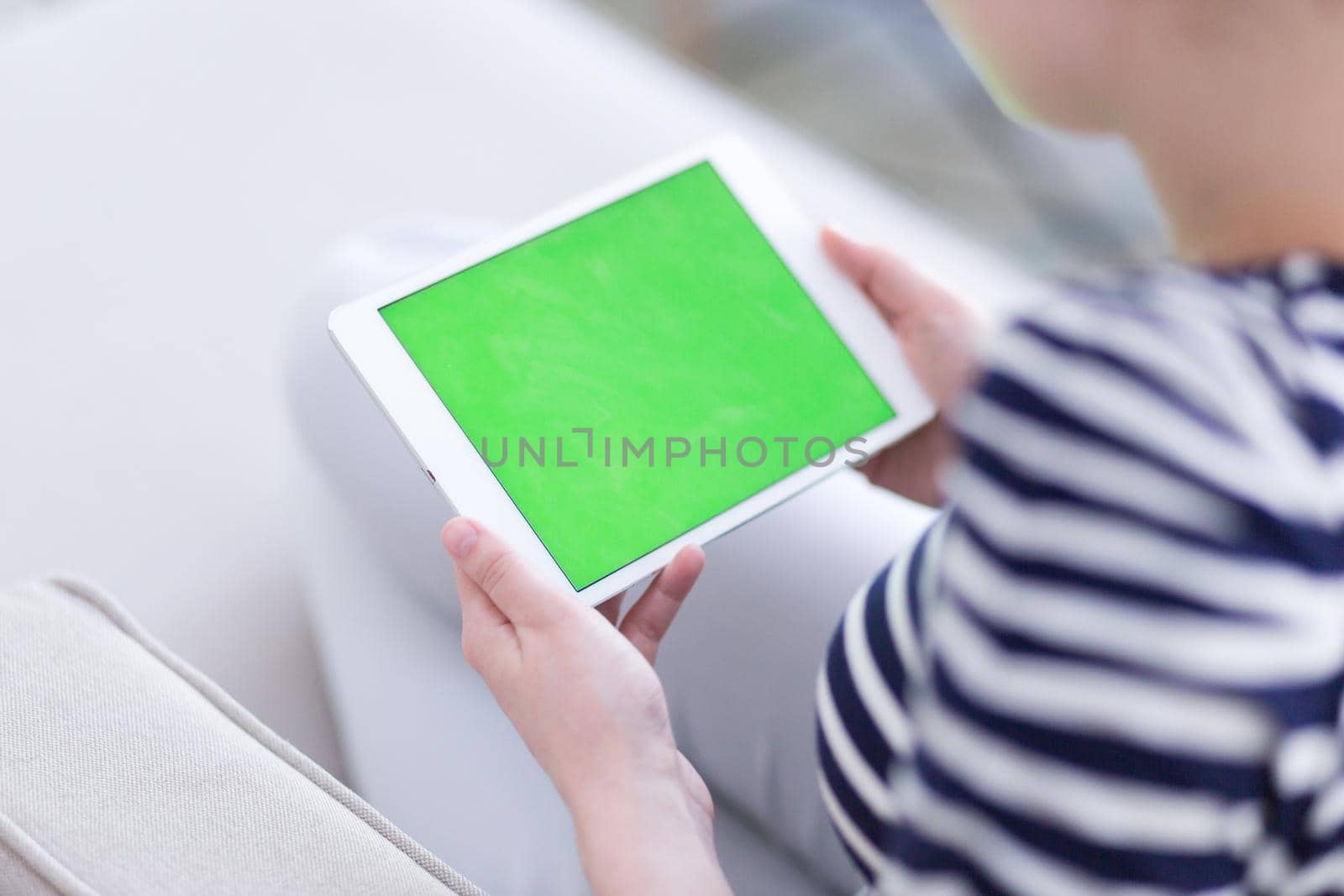 young happy woman on sofa using tablet computer at luxury home