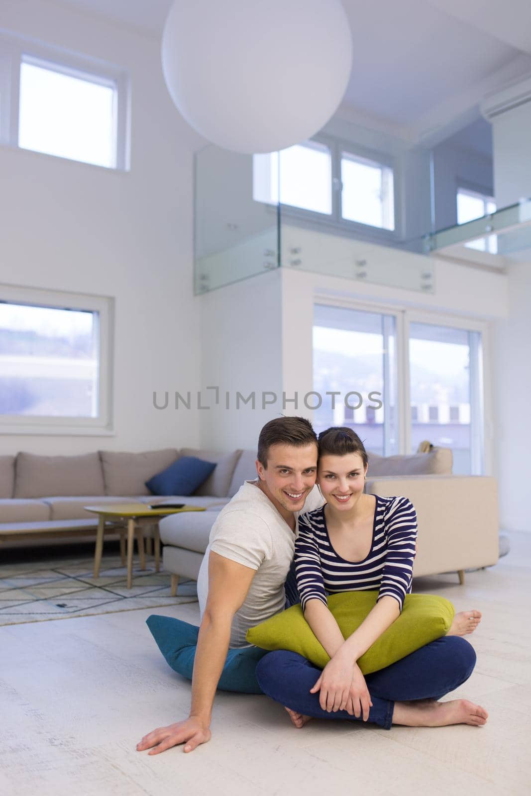 couple sitting on the floor at home by dotshock
