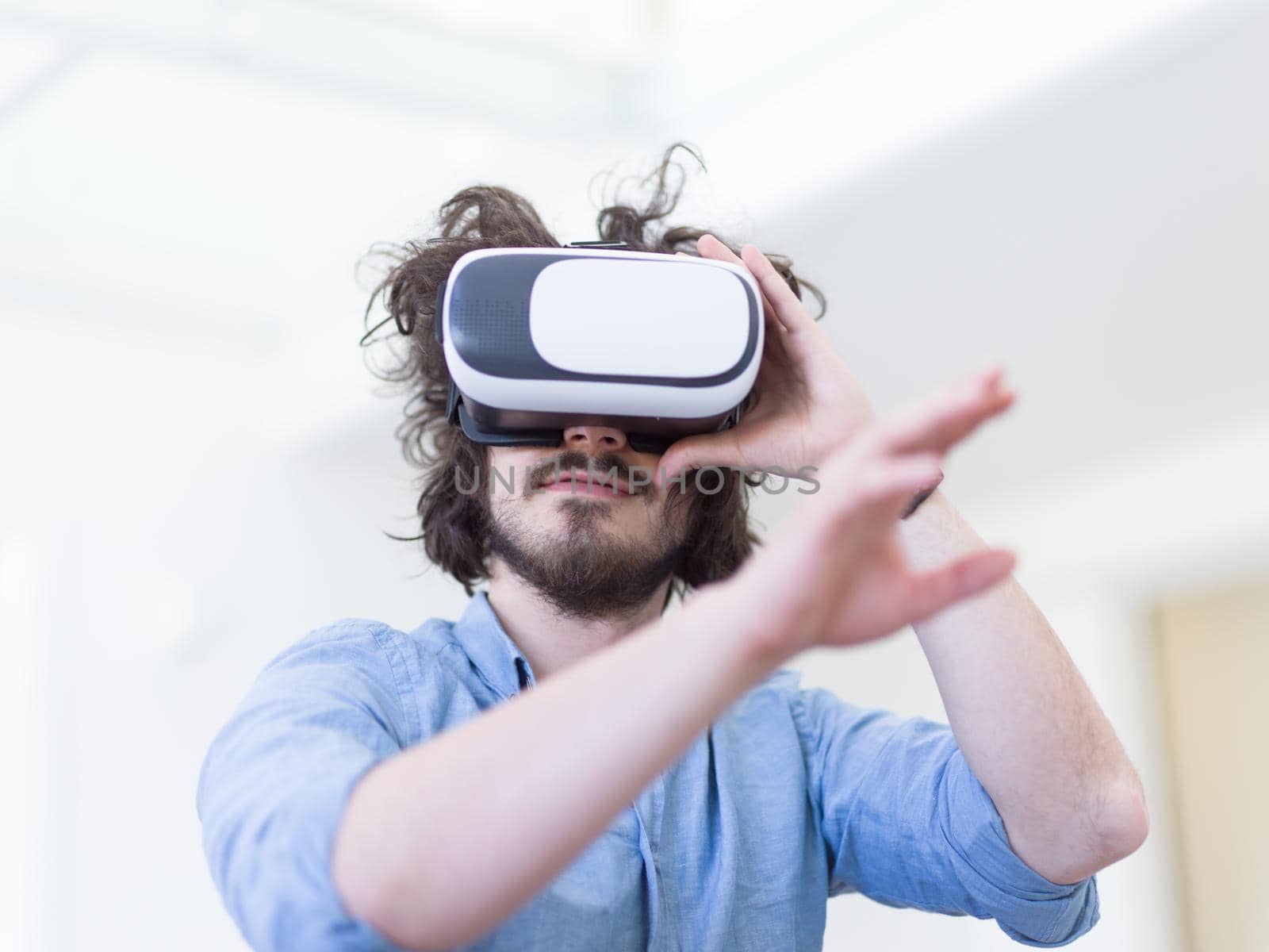 happy man getting experience using VR-headset glasses of virtual reality at home