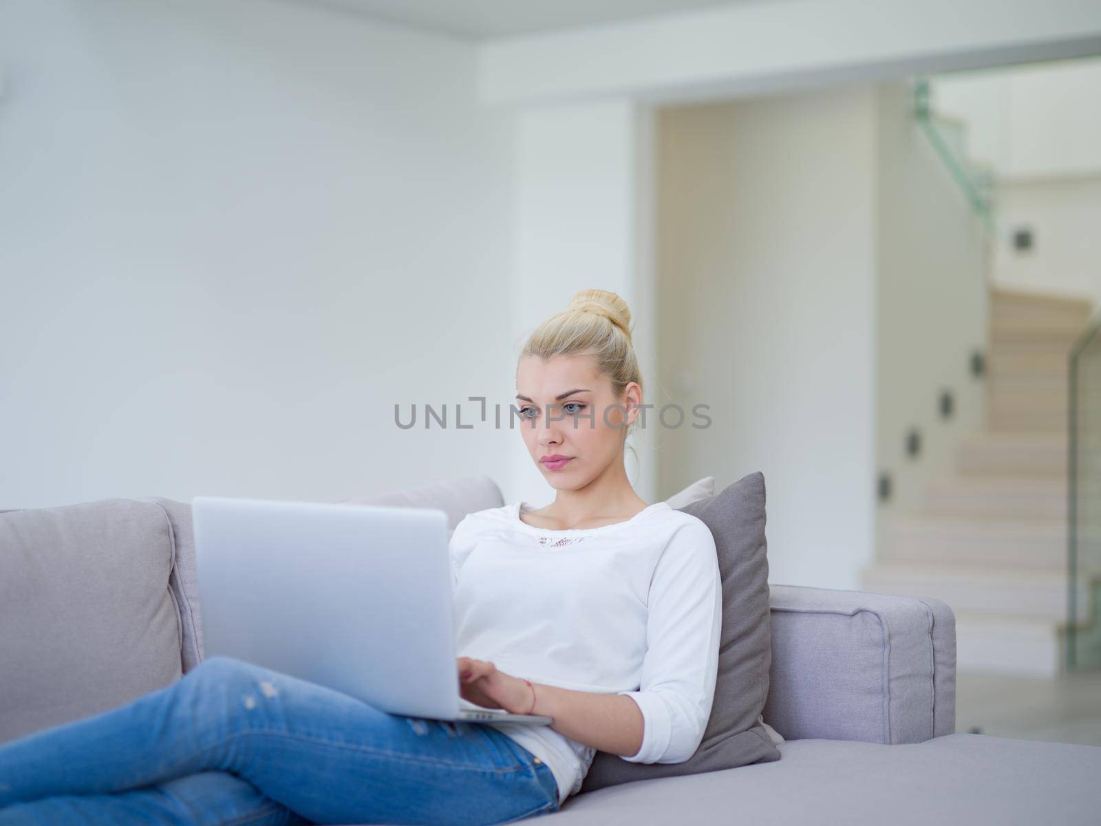 Young woman using laptop at home by dotshock