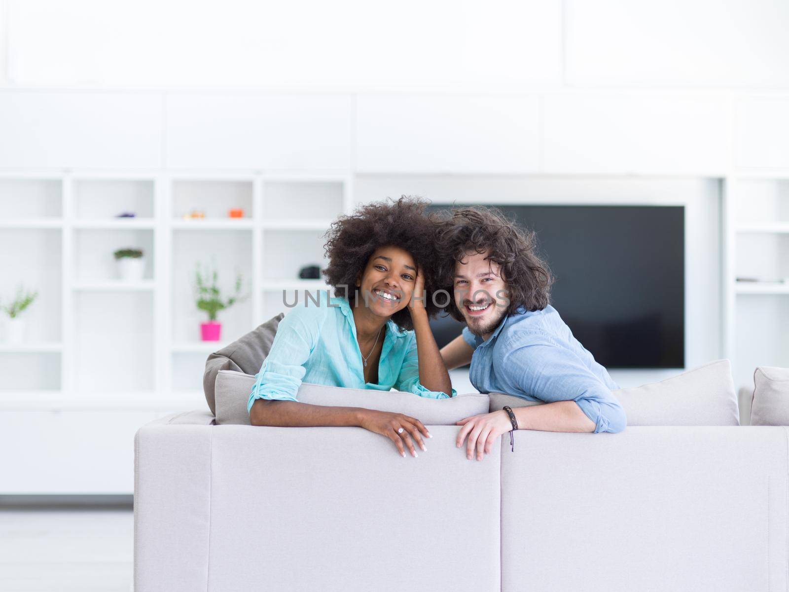 Young multiethnic couple sitting on a sofa in the luxury living room