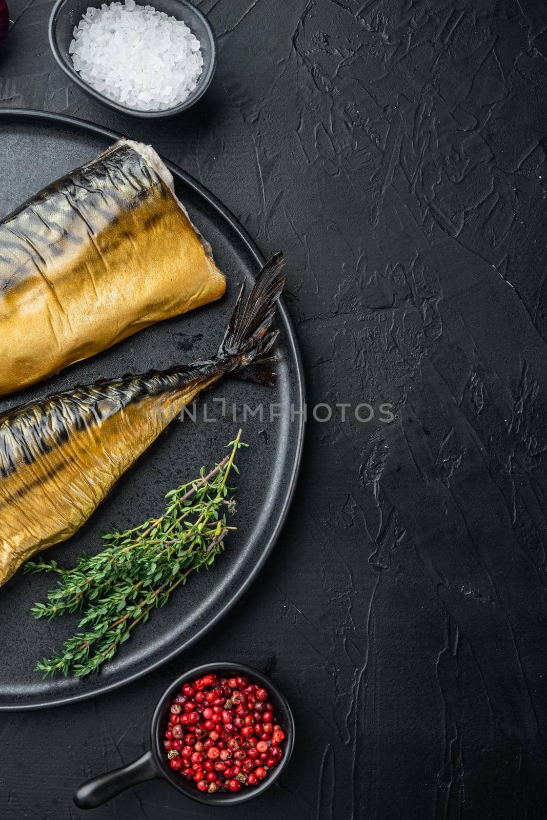 Smoked fish mackerel, on black background, top view flat lay with copy space for text