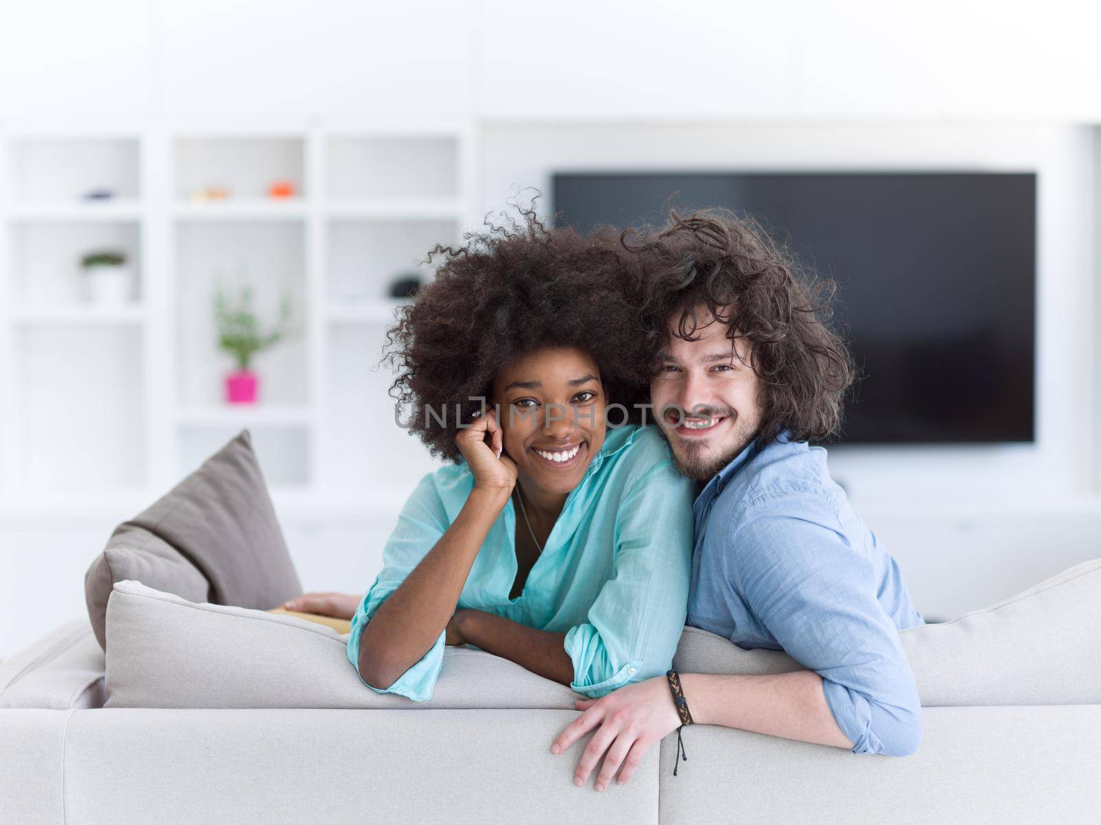 Young multiethnic couple sitting on a sofa in the luxury living room