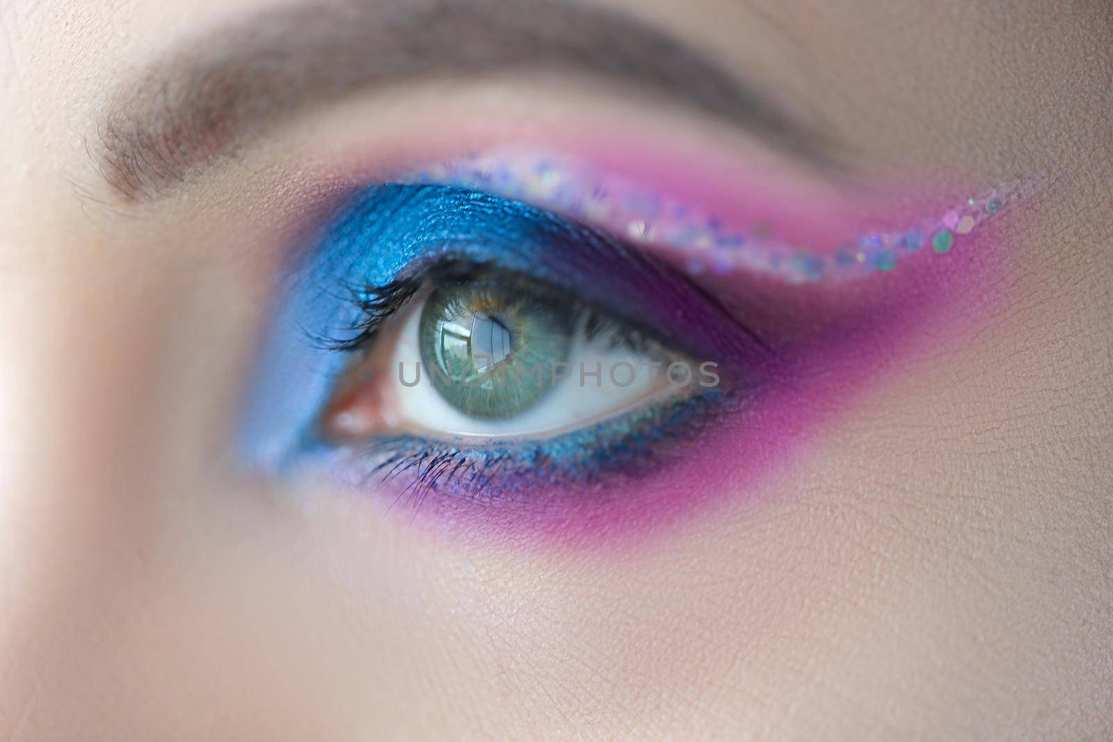 Bright blue eye makeup with sparkles. Stage makeup: basic rules and tips concept