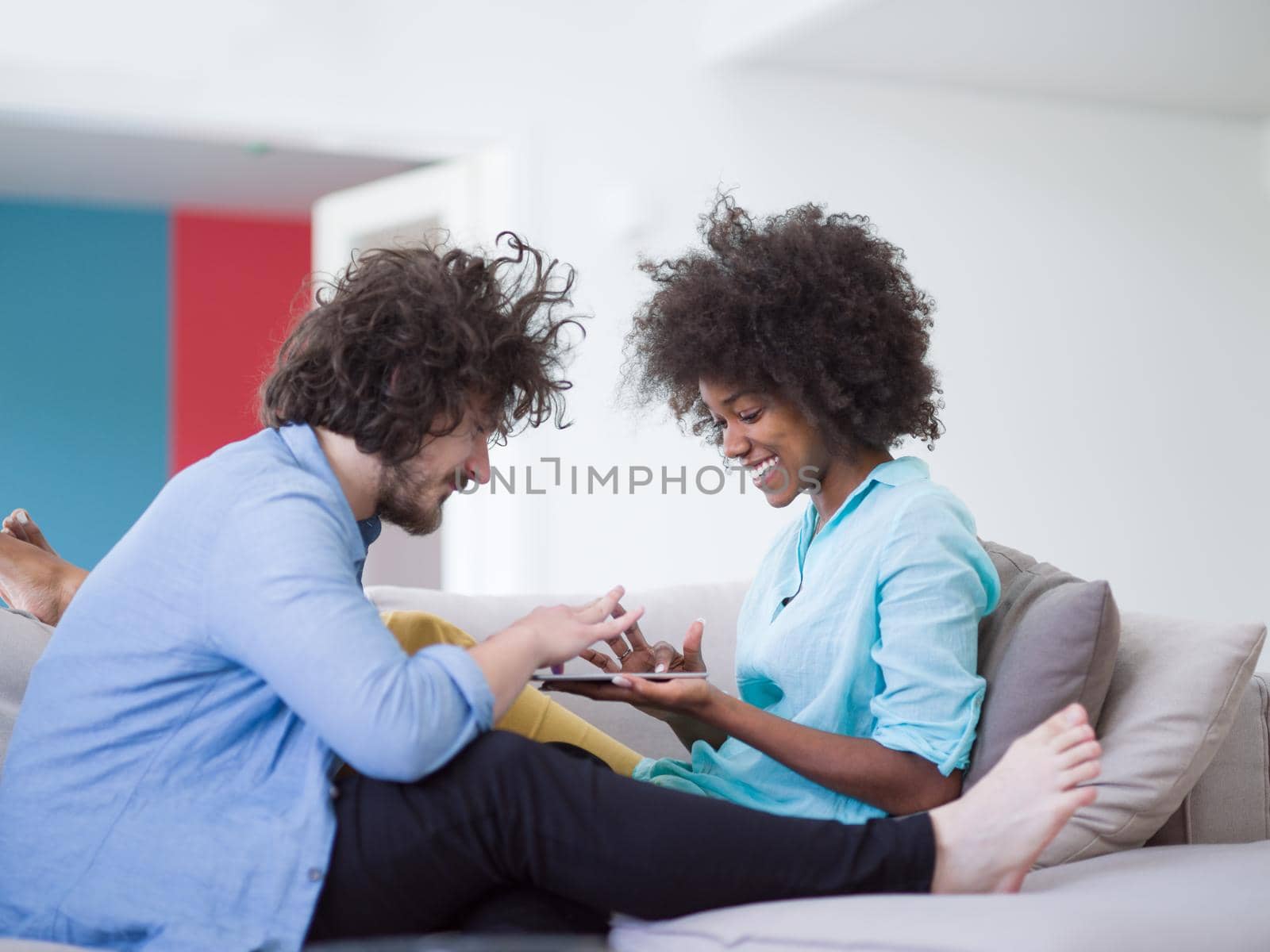 multiethnic couple in living room by dotshock