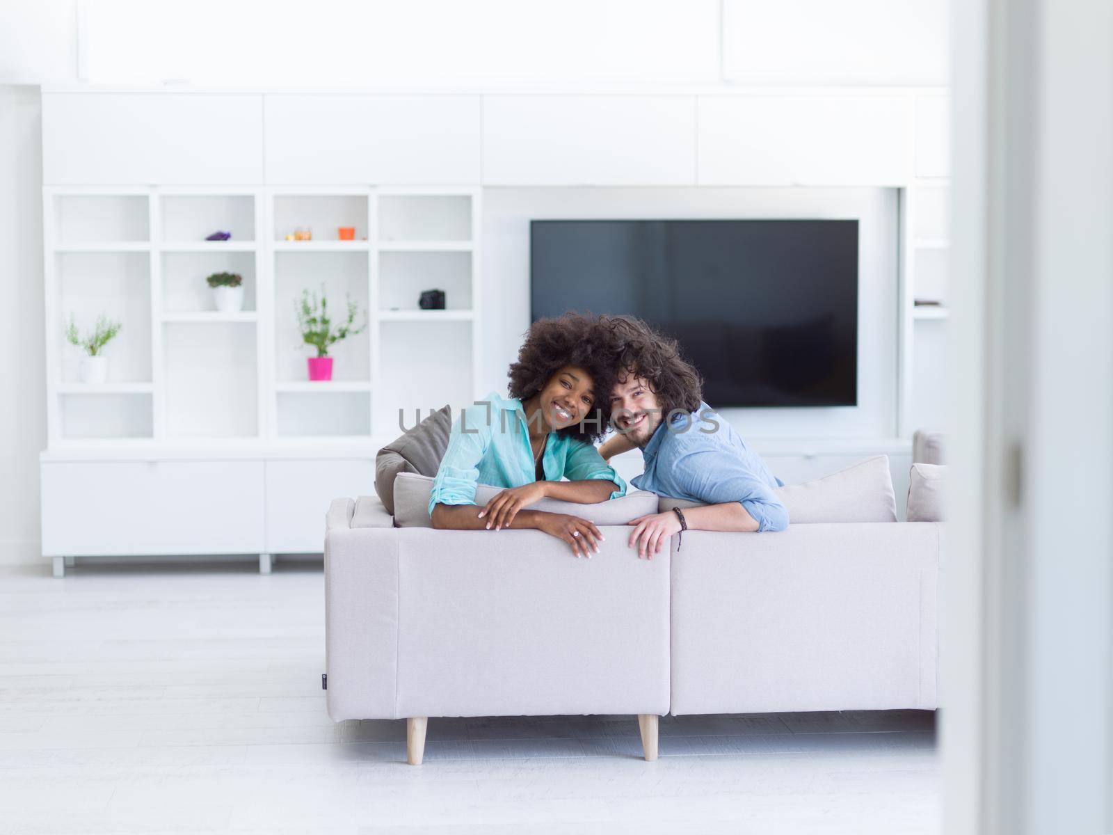 young multiethnic couple in living room by dotshock