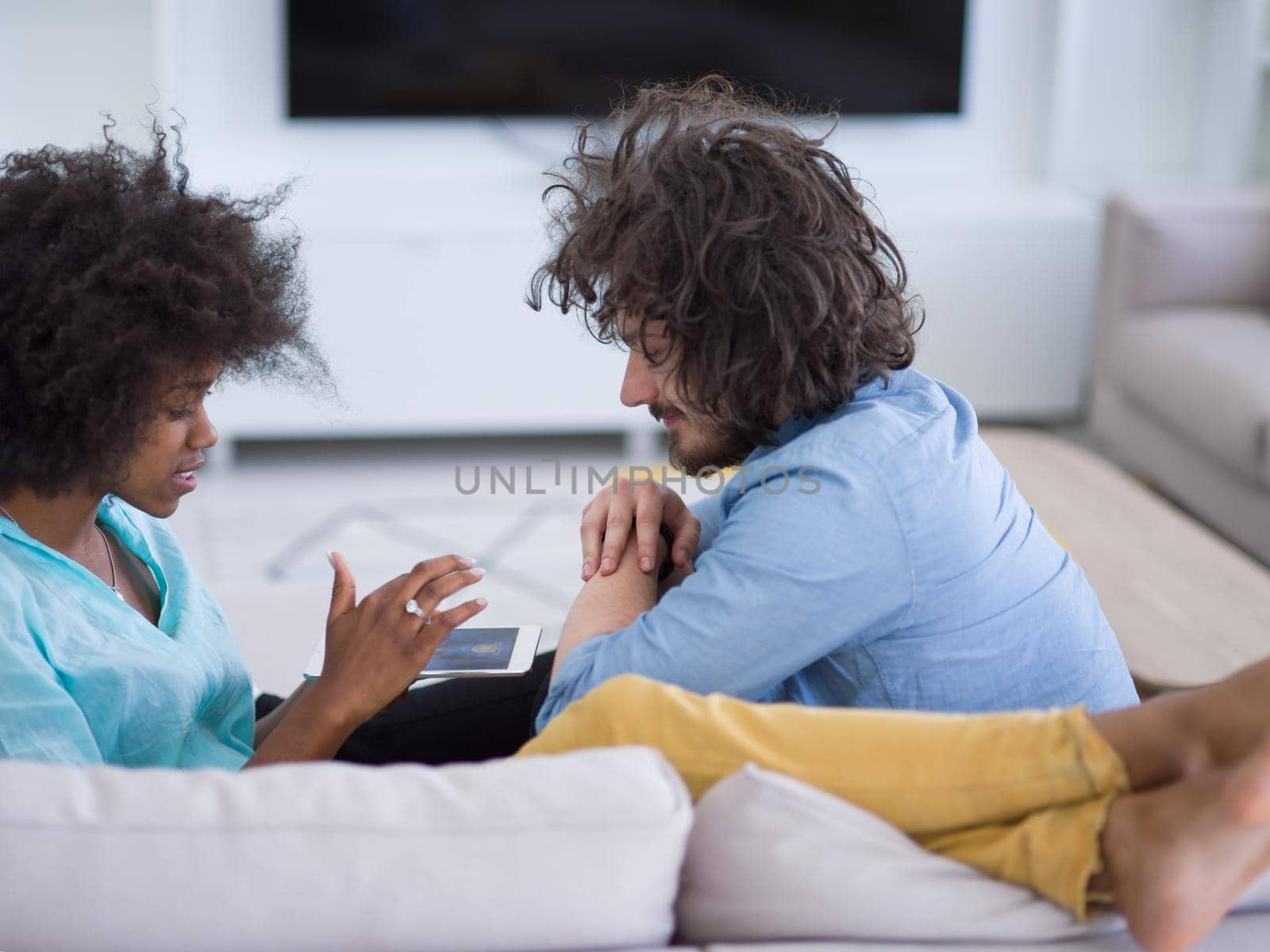 multiethnic couple in living room by dotshock