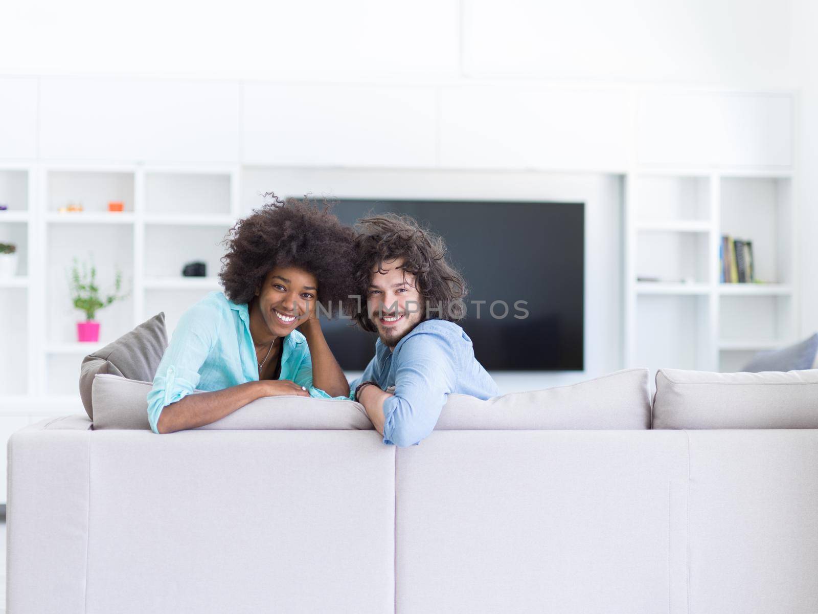 Young multiethnic couple sitting on a sofa in the luxury living room