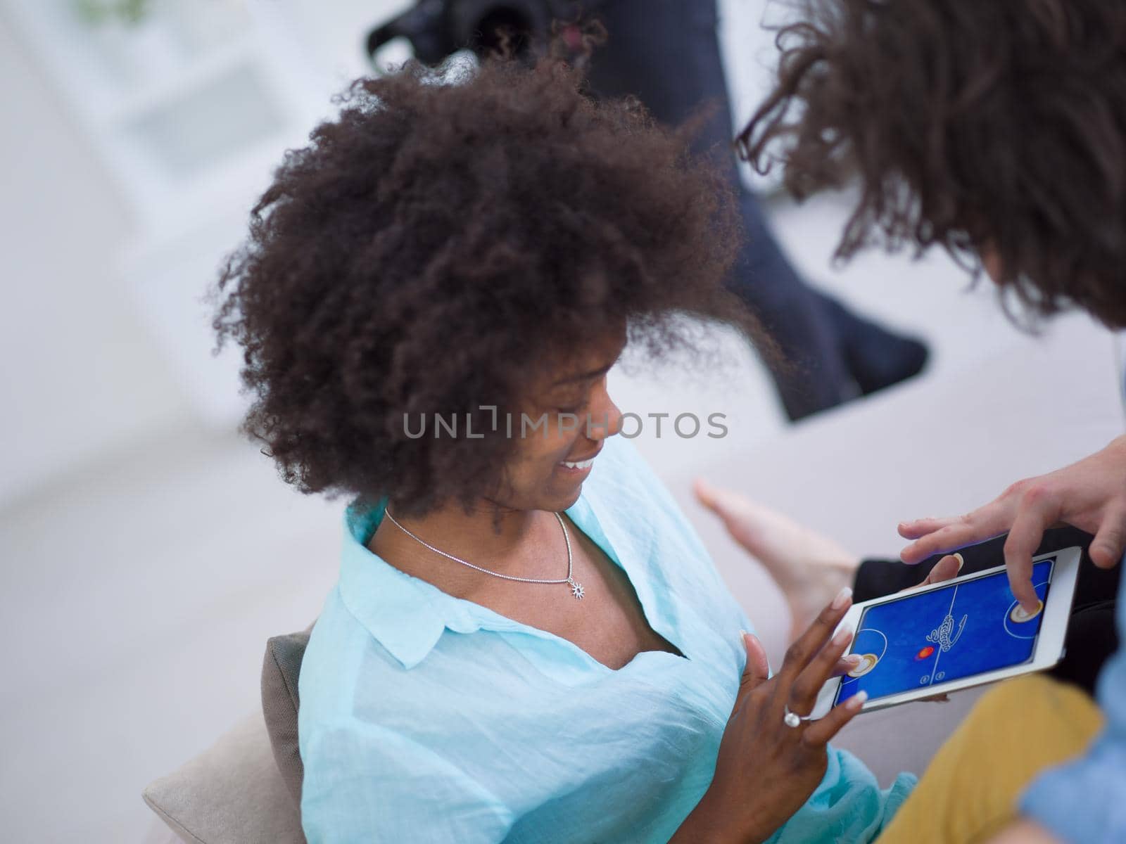 Young multiethnic couple sitting on a sofa in the luxury living room, using a tablet computer