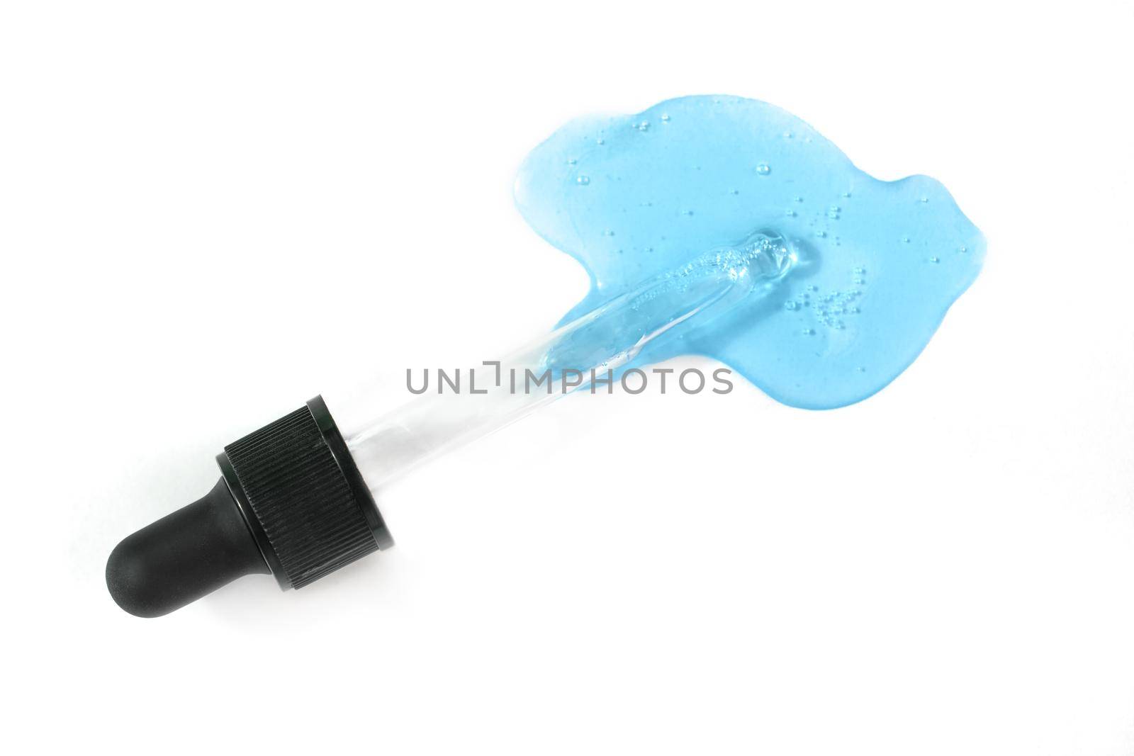 Pipette with blue hyaluronic acid isolated on white background. Cosmetics and healthcare concept closeup. Dose of serum or retinol with air bubbles. Top view. Luxury gel or beauty product presentation