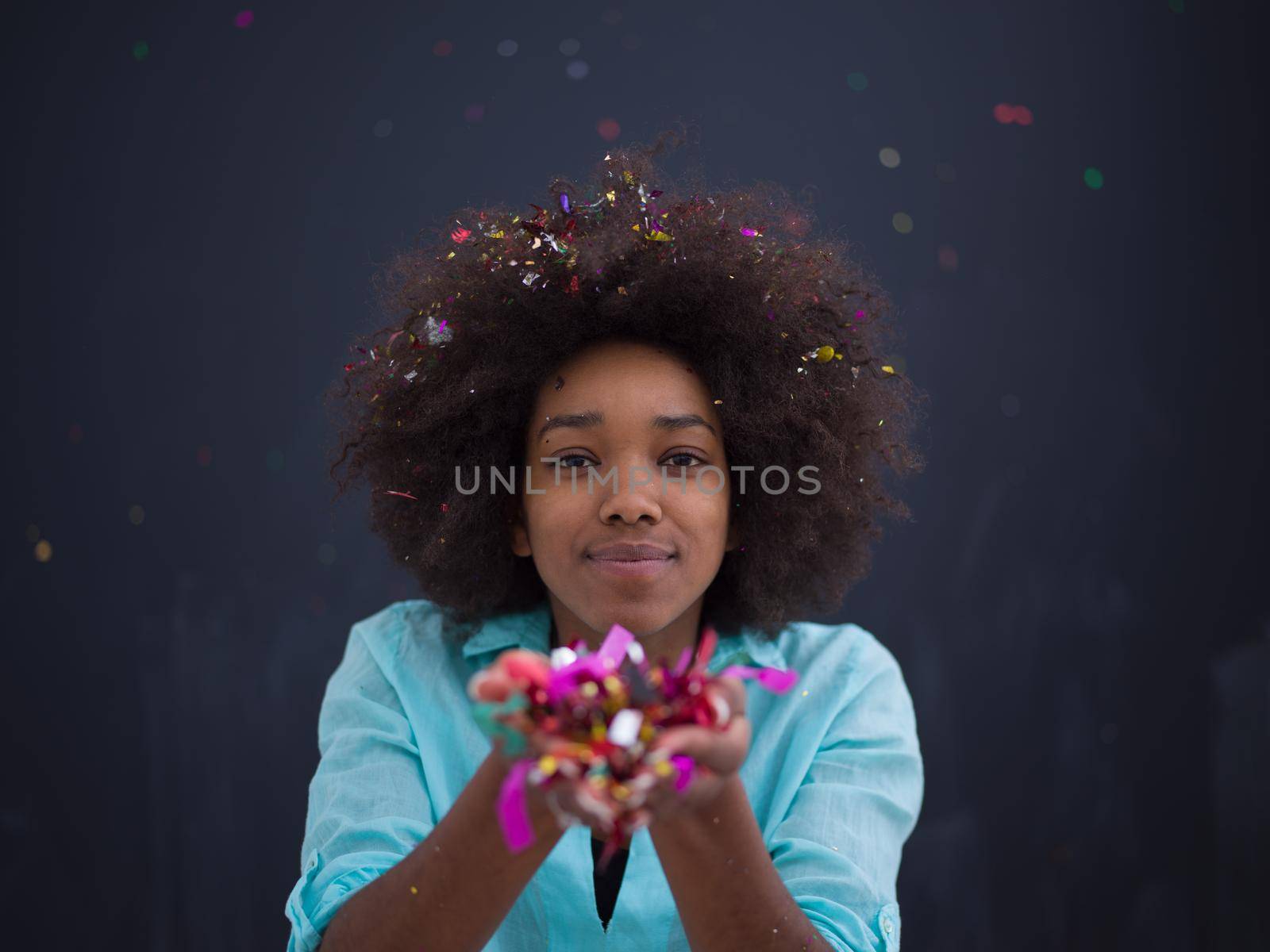 black woman blowing confetti in the air by dotshock