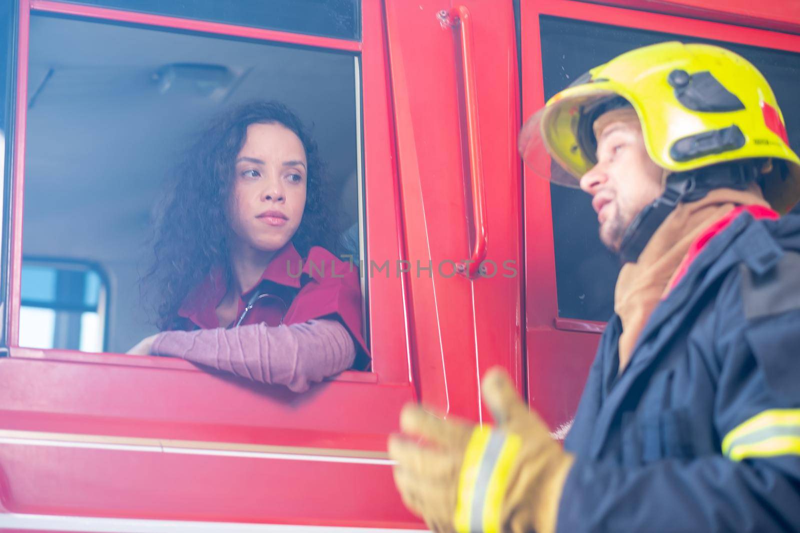 Soft blur of emergency doctor sit in the truck and listen the report from fireman or fighter who help to extinguish fire or help people from bad or dangerous. by nrradmin