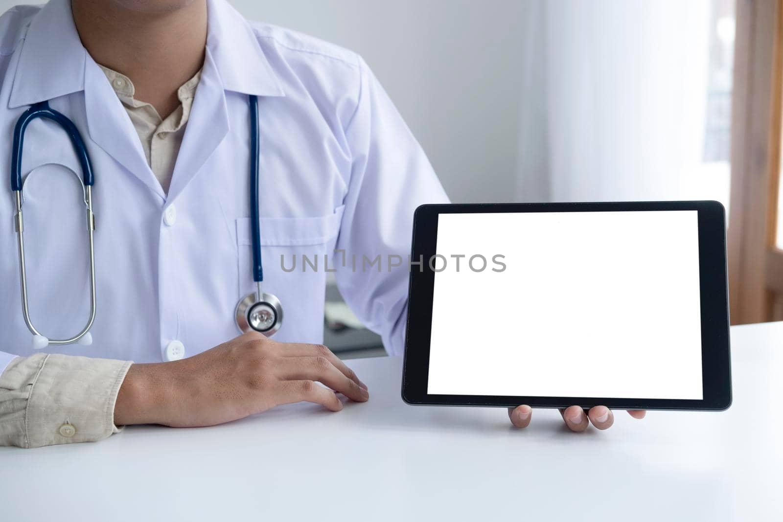 Doctor using computer tablet discussion something with patient. Health care , Hospital and Doctor concept. Copy space of blank computer and tablet screen.