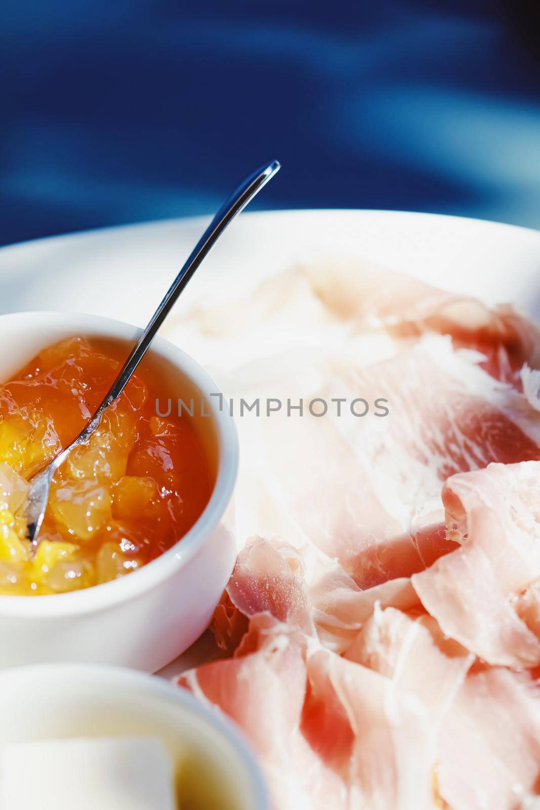 Breakfast outdoors in summer, ham, jam, butter and ham.