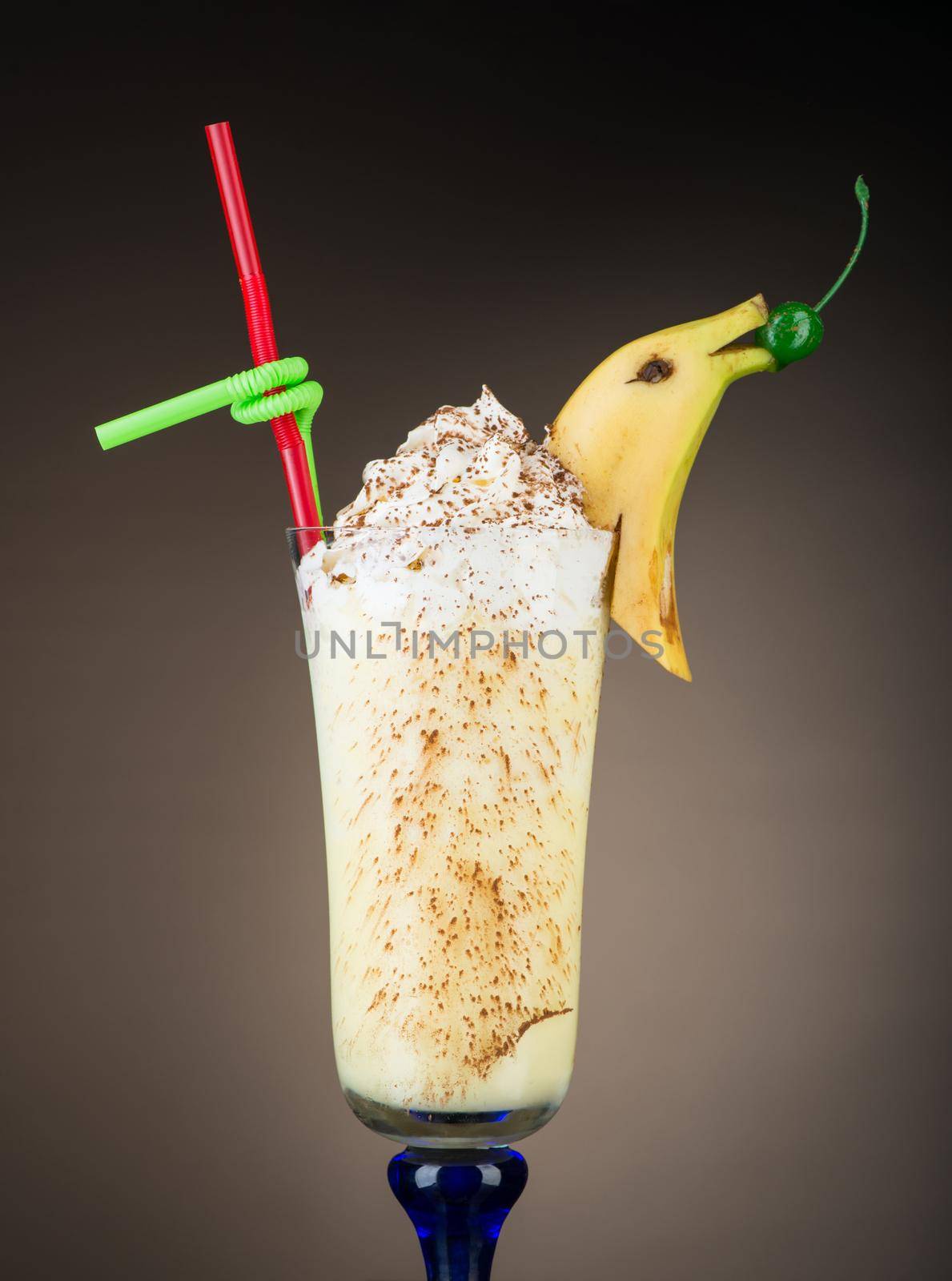 Chocolate fruit cocktail ice cream with banana on brown background, isolated. Summer tropical smoothie