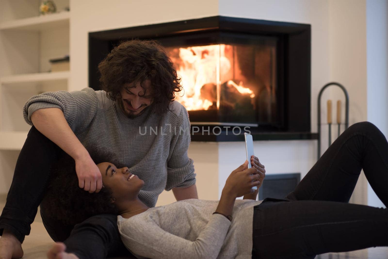 multiethnic couple using tablet computer on the floor by dotshock