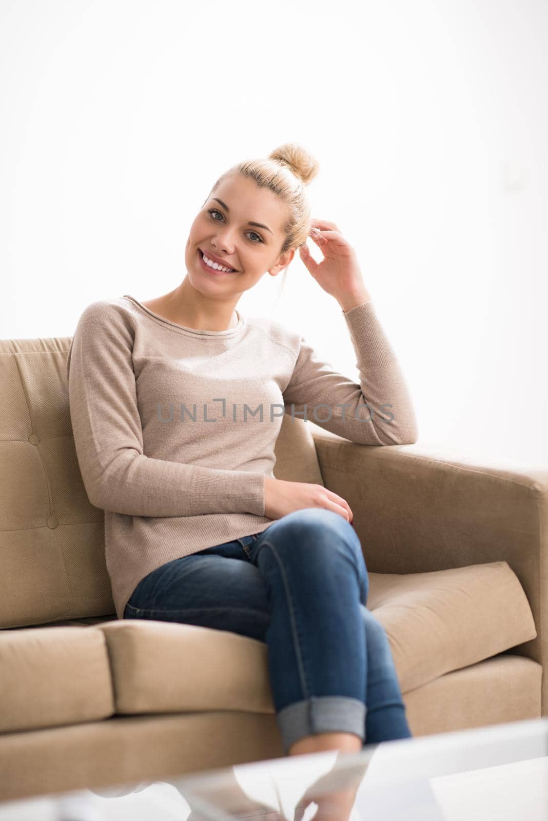 young happy woman sitting on sofa with tablet computer at luxury home