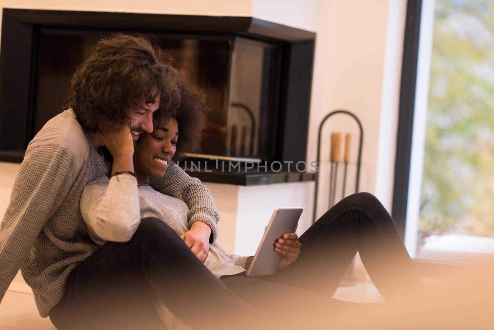 multiethnic couple using tablet computer on the floor by dotshock