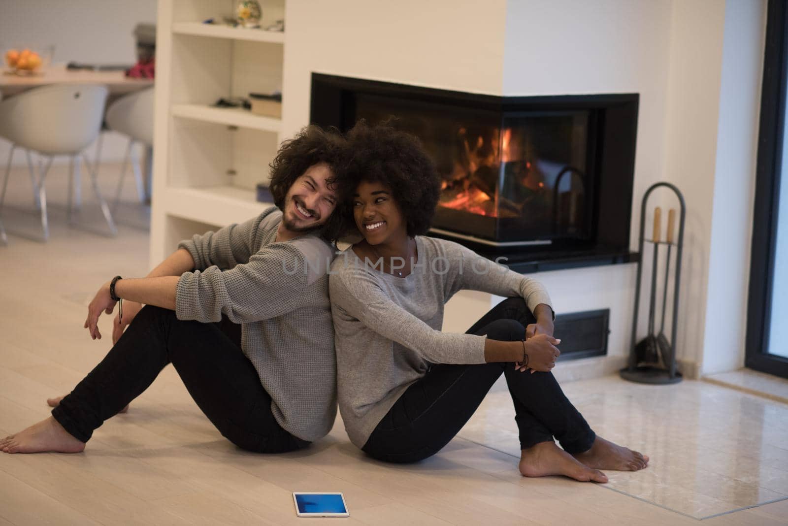 multiethnic couple with tablet computer on the floor by dotshock