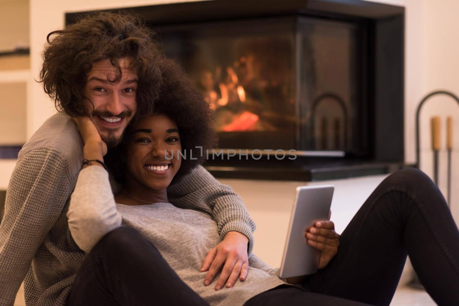 multiethnic couple using tablet computer on the floor by dotshock