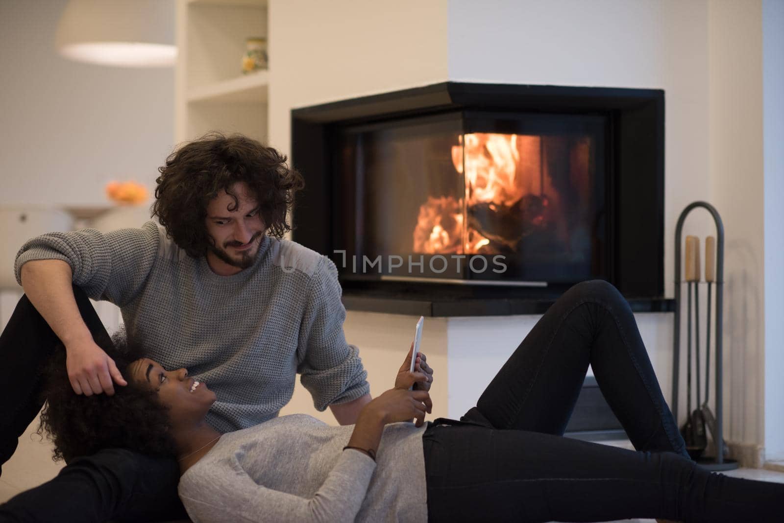 multiethnic couple using tablet computer on the floor by dotshock