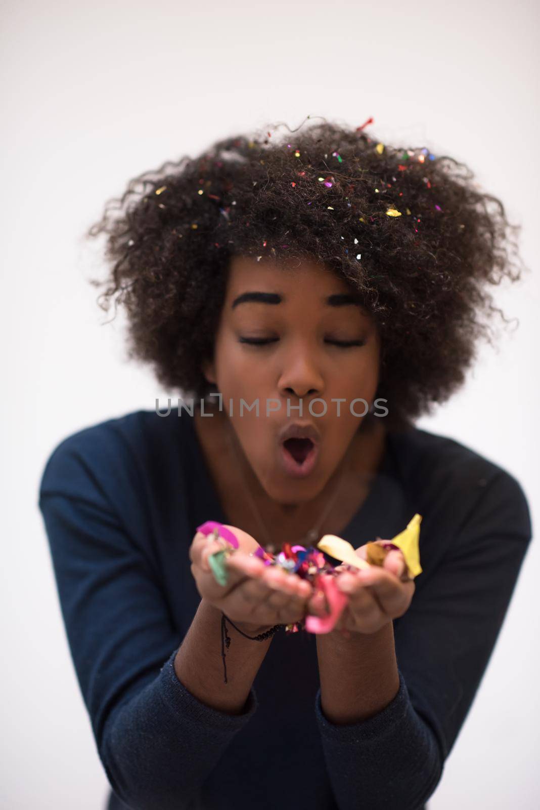 African American woman blowing confetti in the air by dotshock
