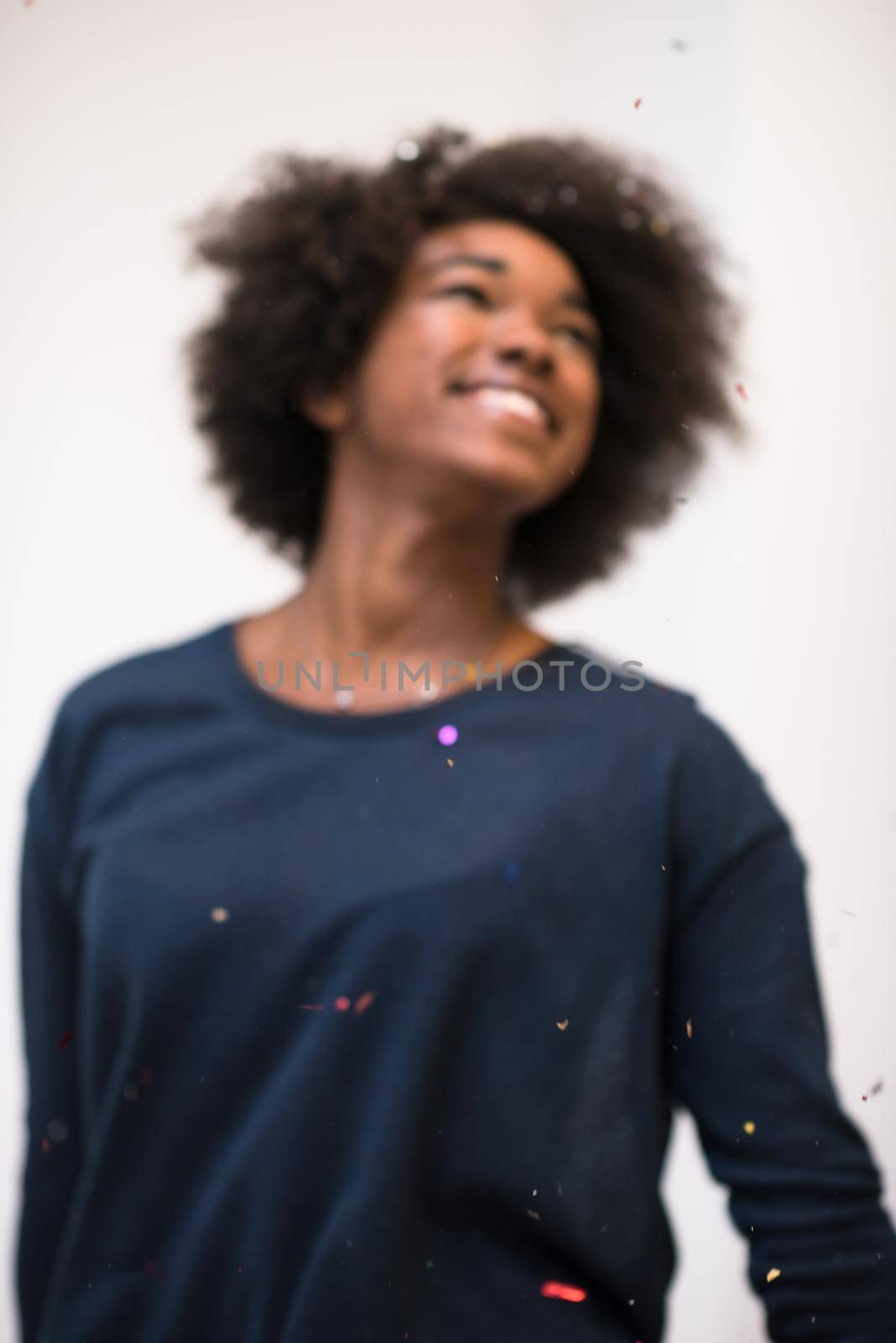 African American woman blowing confetti in the air by dotshock