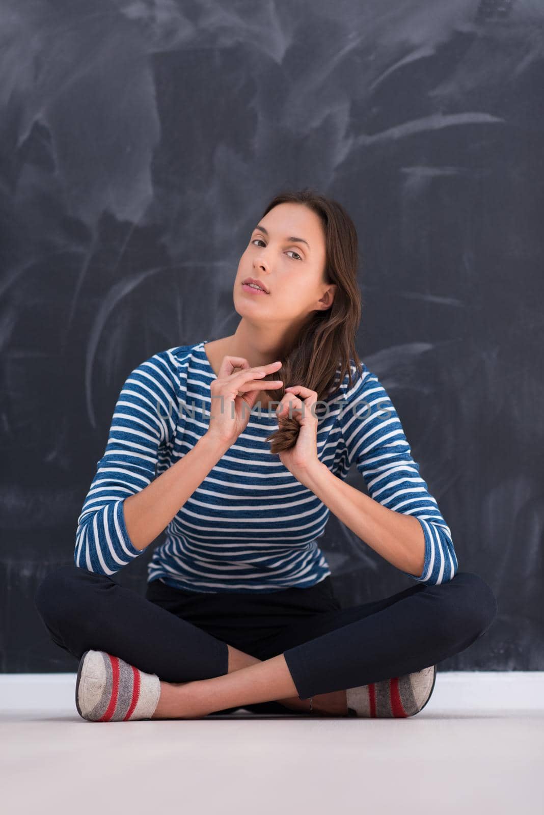 woman sitting in front of chalk drawing board by dotshock