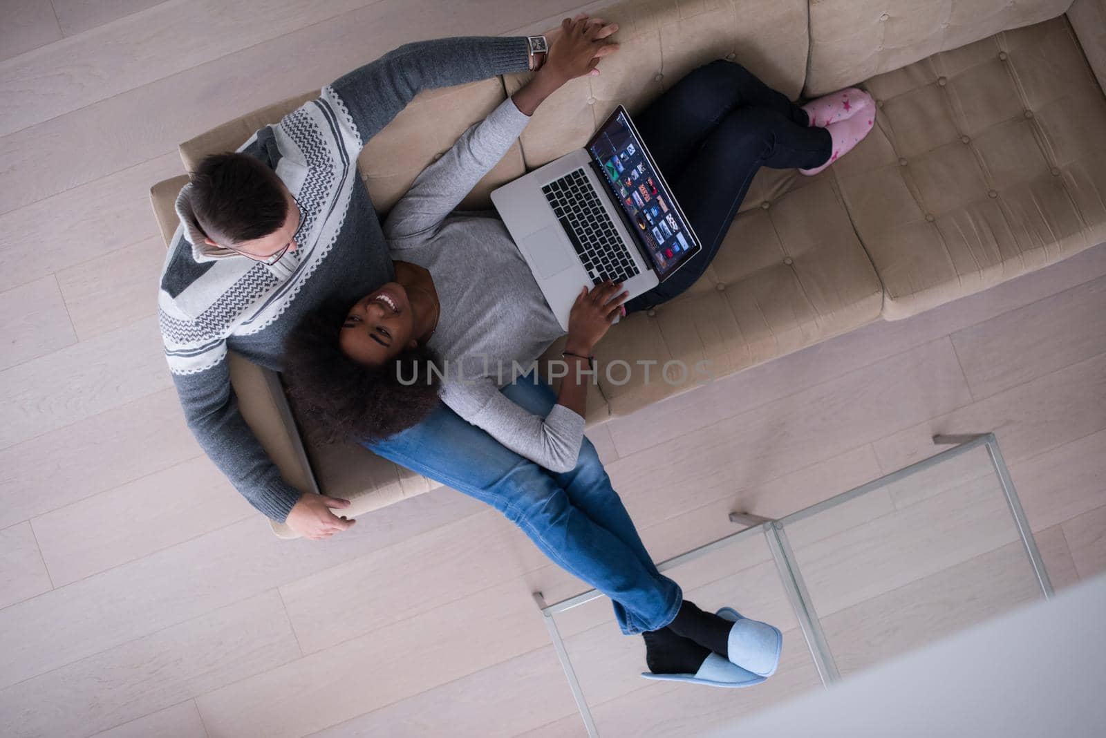 happy multiethnic couple relaxes in the living room by dotshock