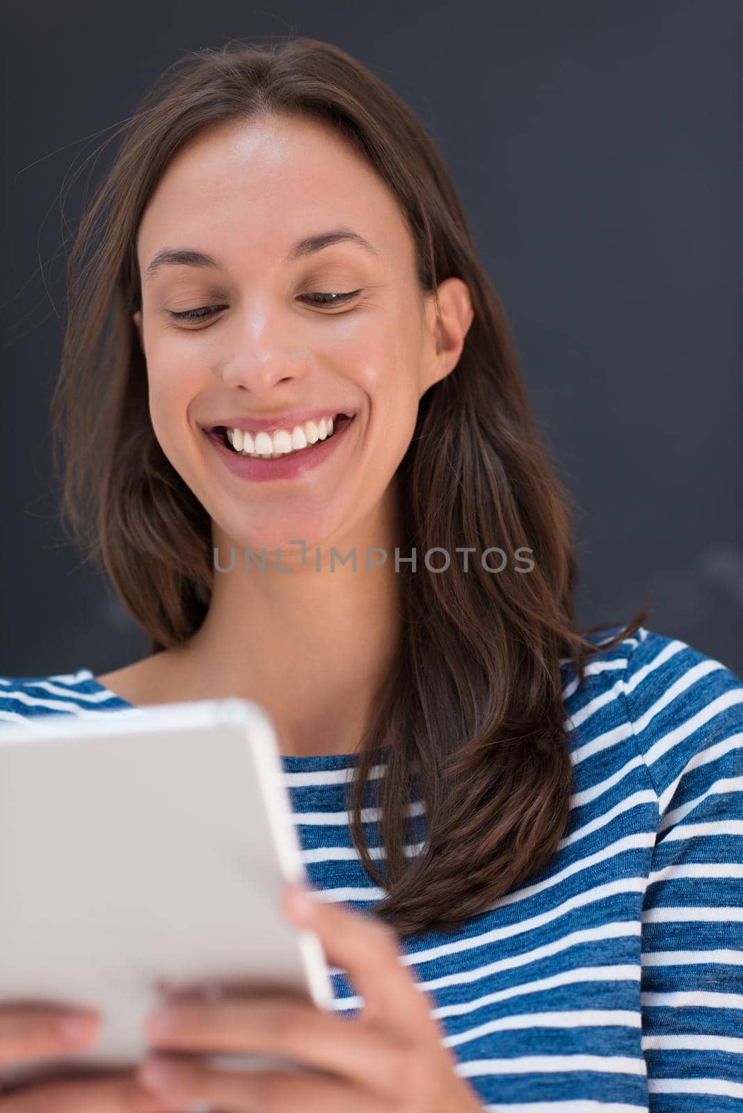 Happy young woman using tablet computer in front of chalk drawing board