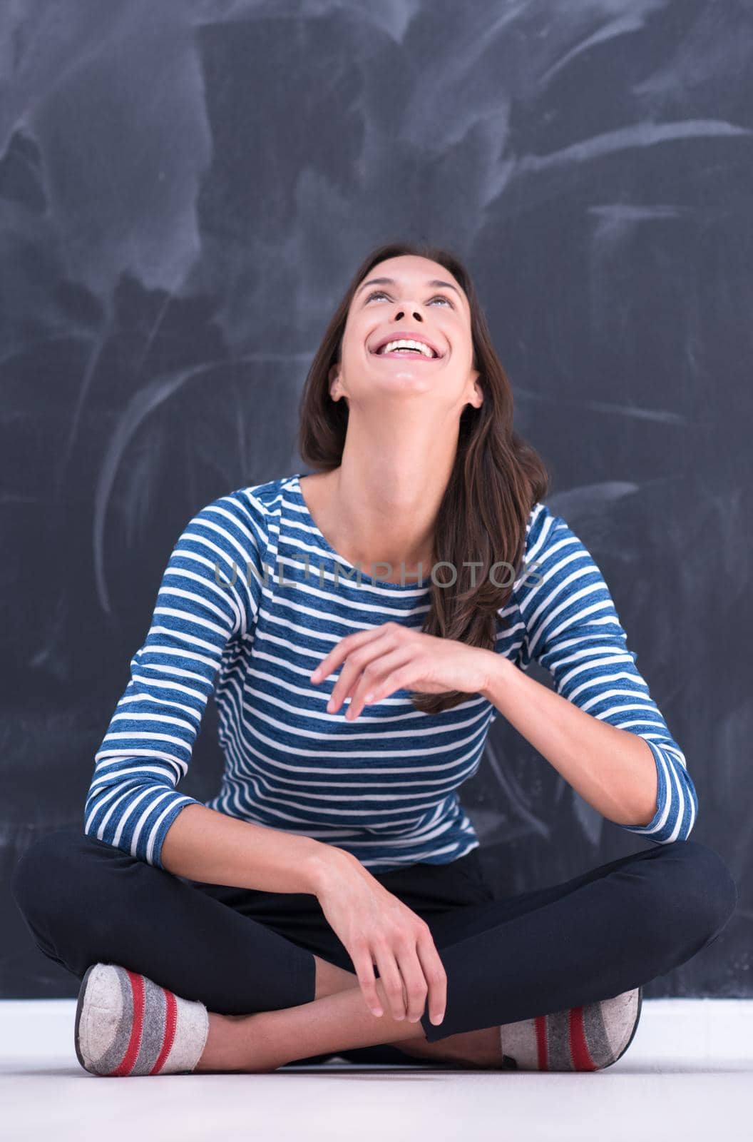 woman sitting in front of chalk drawing board by dotshock